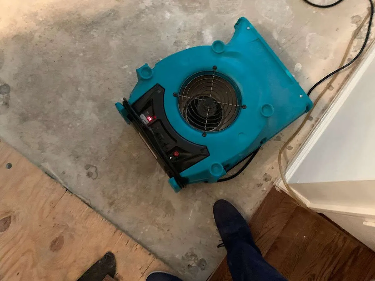 Air mover drying subfloor during Leak Detection & Repair in Monee